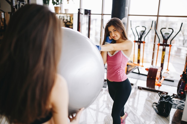 Dos hermosas chicas atléticas se dedican al gimnasio.