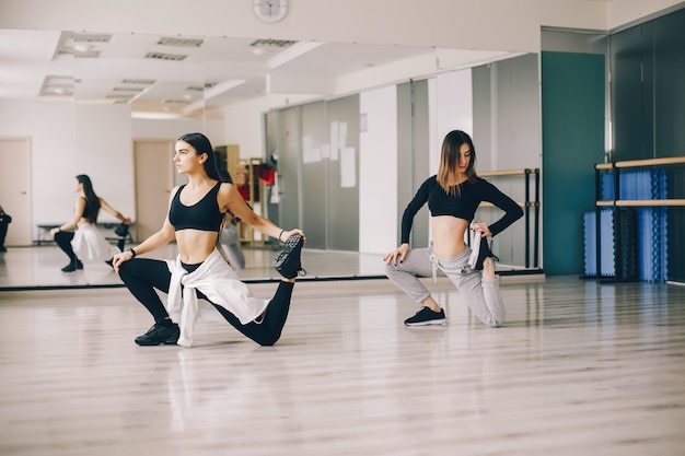 dos hermosas chicas esbeltas haciendo baile y gimnasia en el salón de baile