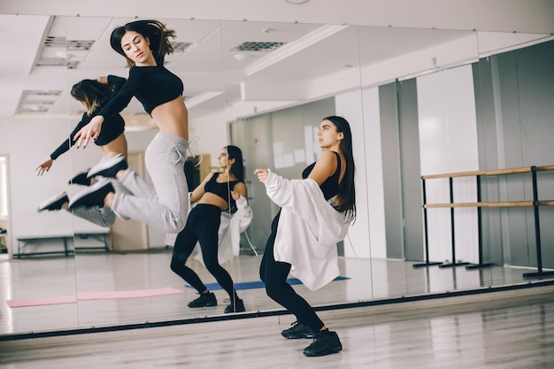 dos hermosas chicas esbeltas haciendo baile y gimnasia en el salón de baile