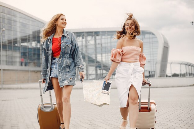 Dos hermosas chicas de pie junto al aeropuerto