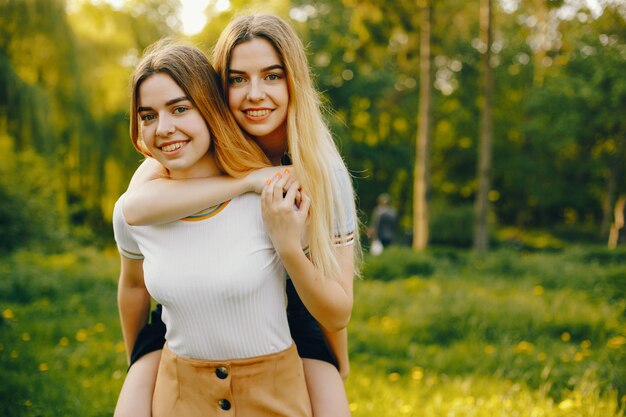 dos hermosas muchachas hermosas jóvenes con pelo rubio brillante y una falda y caminar