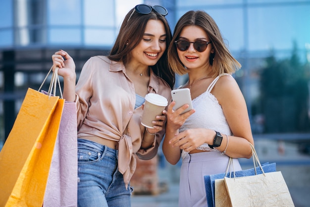 Dos hermosas mujeres de compras en la ciudad