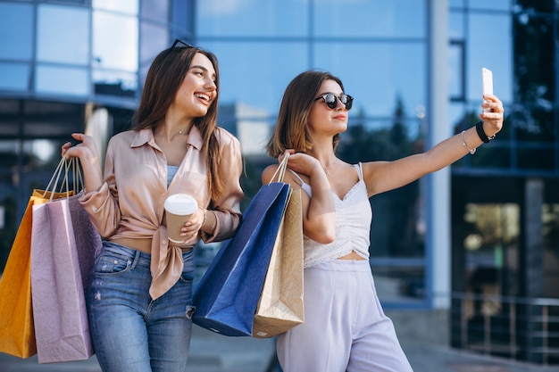 Dos hermosas mujeres de compras en la ciudad