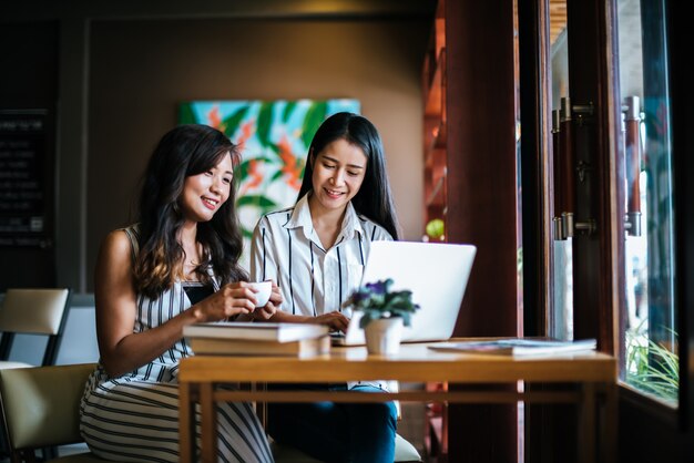 Dos hermosas mujeres hablando todo juntos en la cafetería cafetería