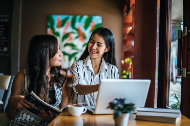 Dos hermosas mujeres hablando todo juntos en la cafetería cafetería