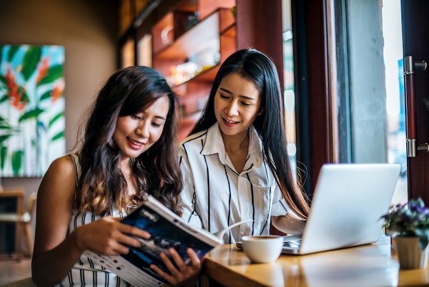 Dos hermosas mujeres hablando todo juntos en la cafetería cafetería