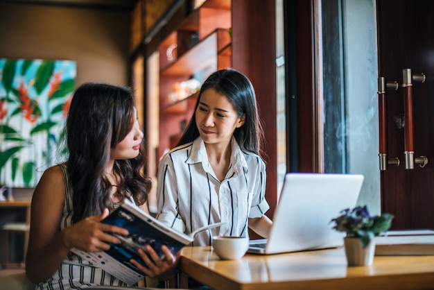 Dos hermosas mujeres hablando todo juntos en la cafetería cafetería