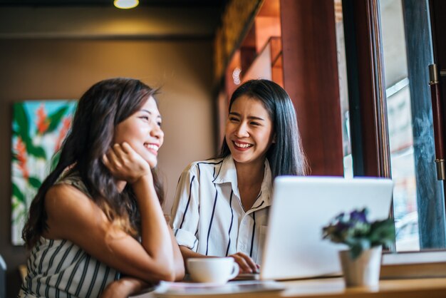 Dos hermosas mujeres hablando todo juntos en la cafetería cafetería