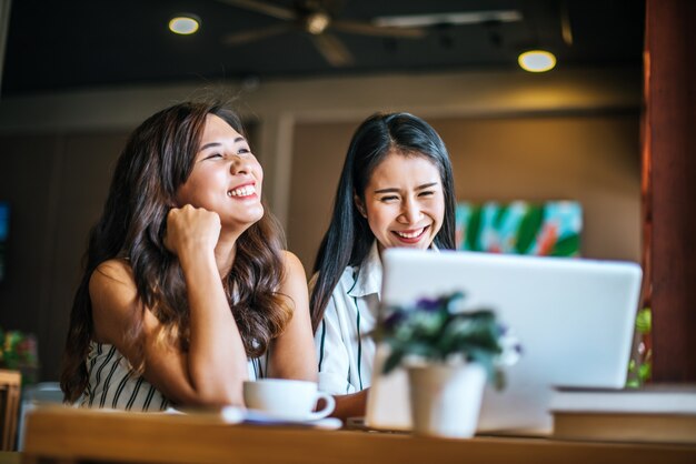 Dos hermosas mujeres hablando todo juntos en la cafetería cafetería