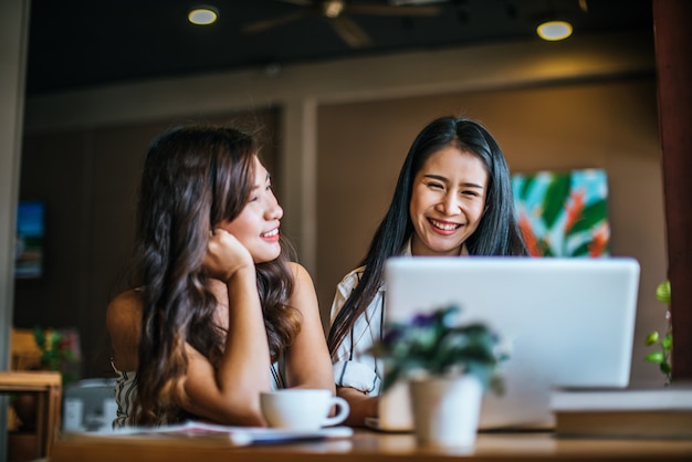 Dos hermosas mujeres hablando todo juntos en la cafetería cafetería