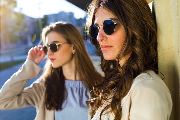 Dos hermosas mujeres jóvenes posando en la calle.