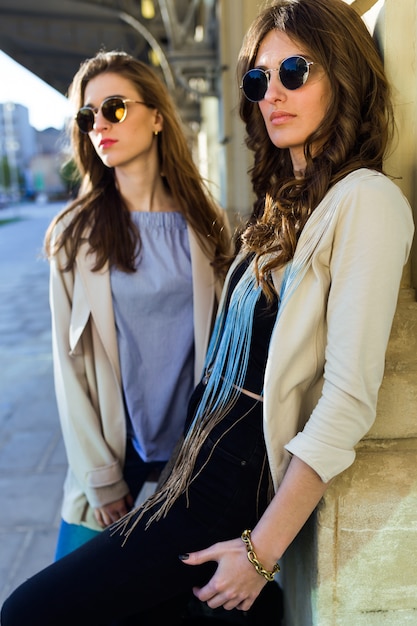 Dos hermosas mujeres jóvenes posando en la calle.