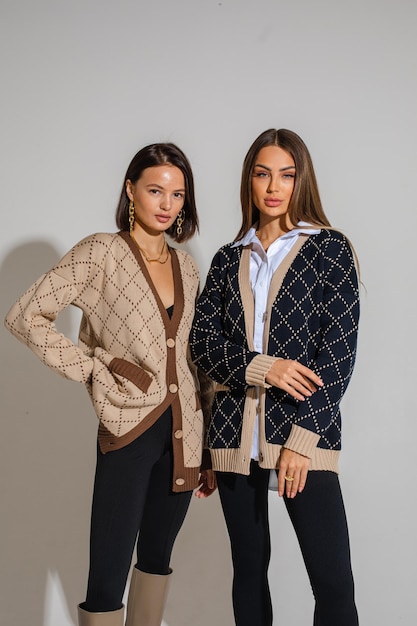 Dos hermosas mujeres posando para la cámara con ropa de moda