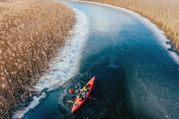 Dos hombre atlético flota en un bote rojo en el río