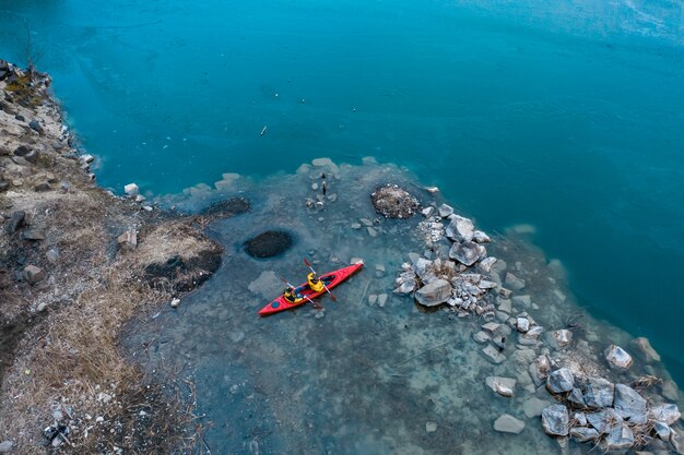 Dos hombre atlético flota en un bote rojo en el río