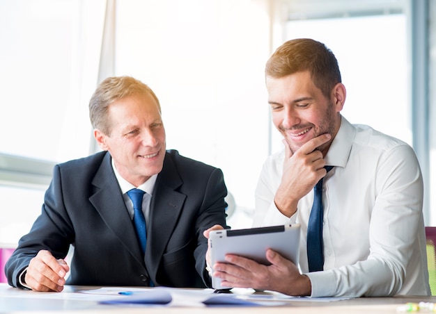 Foto gratuita dos hombre de negocios discutiendo con tableta digital