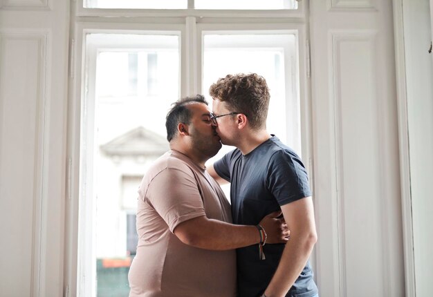 dos hombres se abrazan y besan en la casa