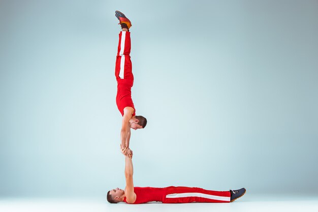 Los dos hombres acrobáticos en equilibrio posan