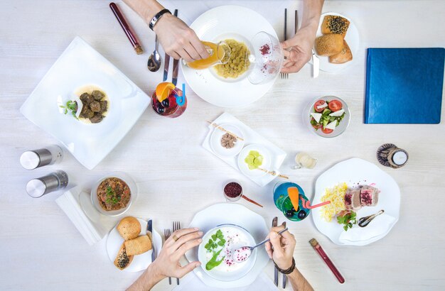 dos hombres almorzando con dushbara, dovga, dolma, arroz y pollo envuelto