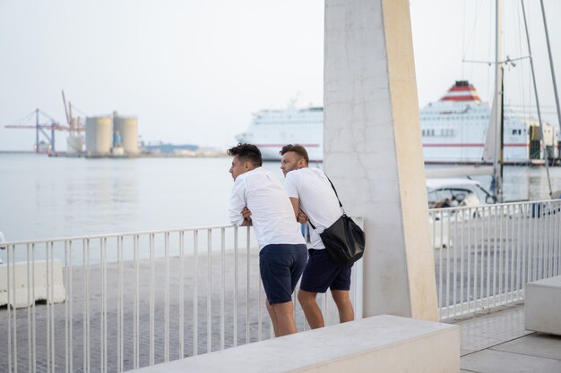 Dos hombres de un amigo en el paseo marítimo de la ciudad de Málaga.