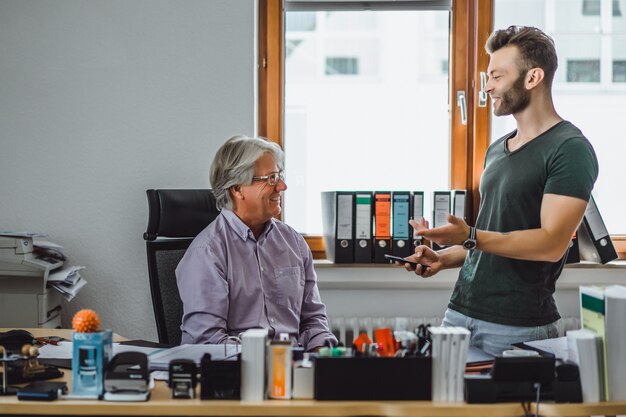 Dos hombres de diferentes edades en la oficina, socios de negocios.