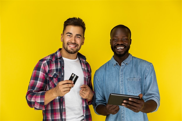 Dos hombres están felices de usar tarjeta y tableta