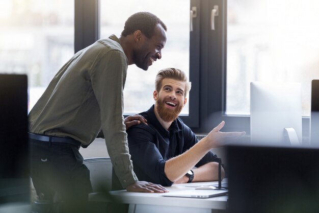 Dos hombres felices trabajando juntos en un nuevo proyecto de negocios