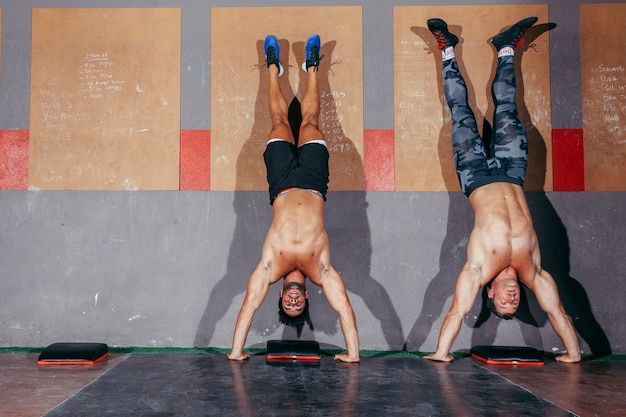 Dos hombres haciendo paradas de mano