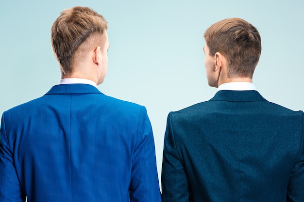 Dos hombres jóvenes con estilo en un traje. Vista trasera desde atrás.