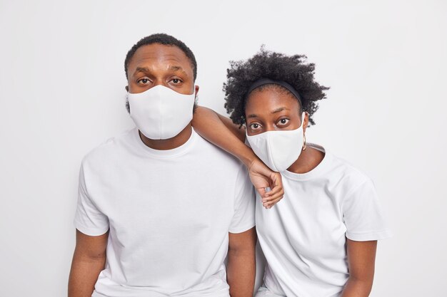 Dos hombres y mujeres afroamericanos negros usan máscaras protectoras durante la pandemia del covid 19