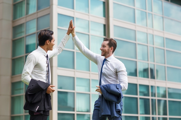 Dos hombres de negocios adultos felices fiving alto