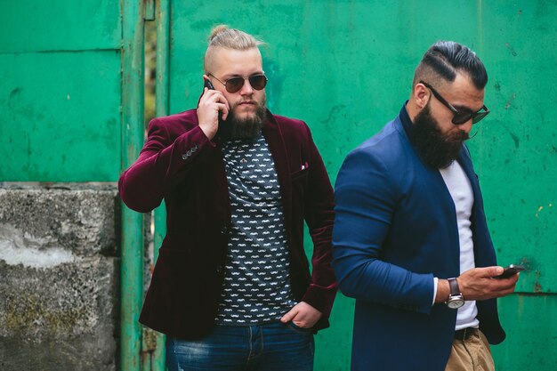 Dos hombres de negocios hablando por teléfono en la ciudad.