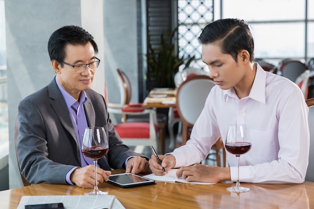 Dos hombres de negocios que discuten proyecto en el restaurante