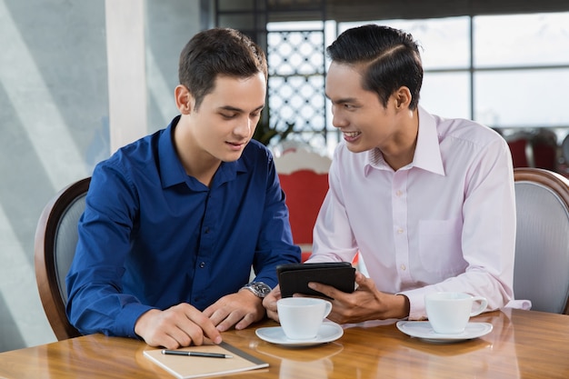 Dos hombres de negocios que usa la tableta presenta experiencia