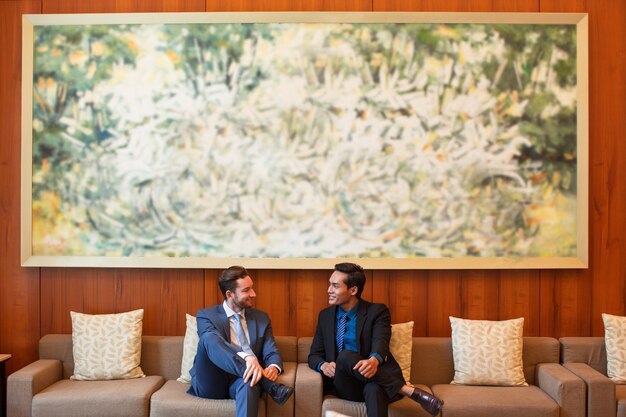 Dos hombres de negocios sonrientes charlando en el salón