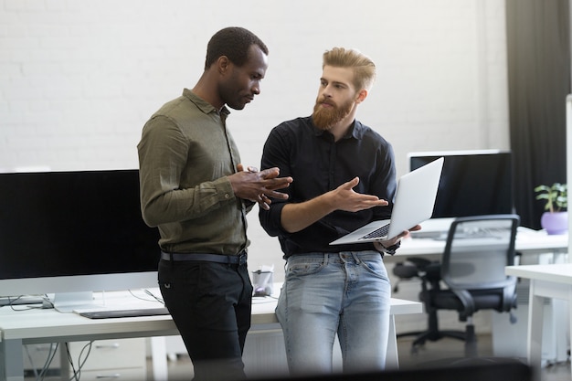 Dos hombres de negocios trabajando juntos en la computadora portátil