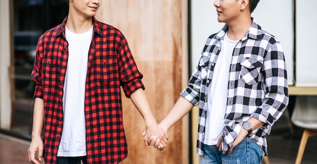 Dos hombres que se aman están cogidos de la mano.