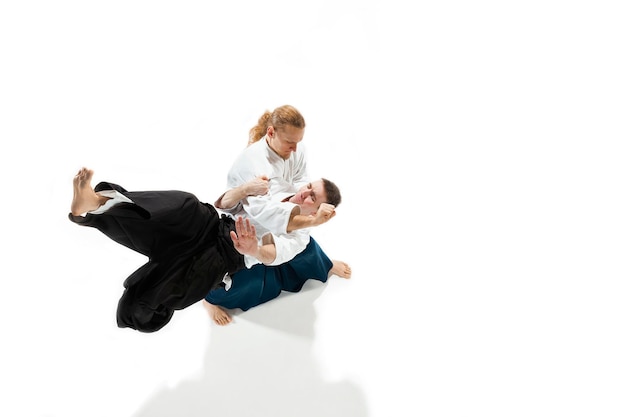 Los dos hombres que luchan en el entrenamiento de Aikido en la escuela de artes marciales.