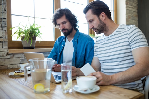 Dos hombres que usan una computadora portátil