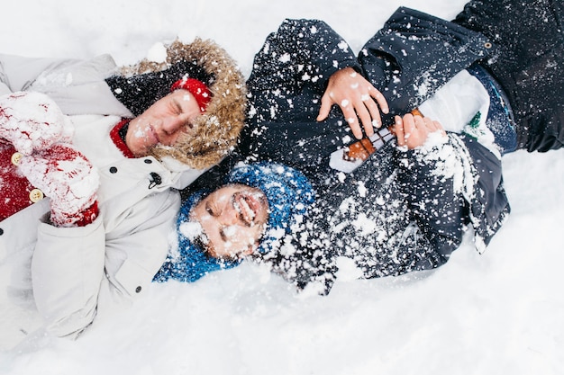 Dos hombres recostados cubiertos de nieve