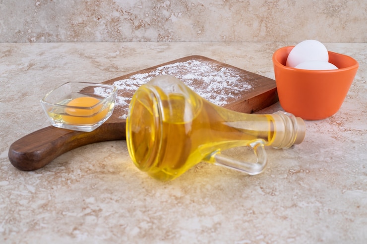 Foto gratuito dos huevos de gallina blancos frescos con una botella de vidrio de aceite