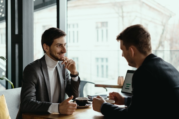 Dos joven empresario tener una reunión exitosa en el restaurante.