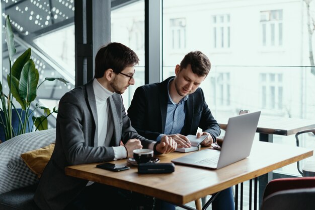 Dos joven empresario tener una reunión exitosa en el restaurante.