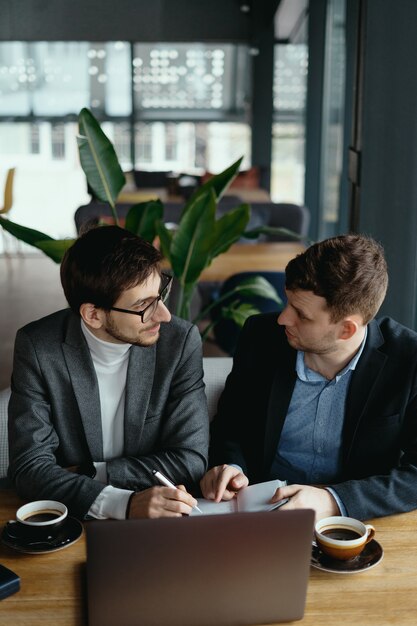 Dos joven empresario tener una reunión exitosa en el restaurante.