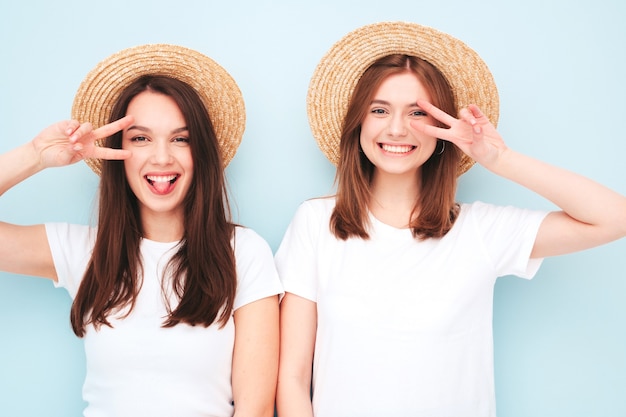 Dos joven hermosa mujer sonriente hipster en ropa de jeans y camiseta blanca de verano de moda