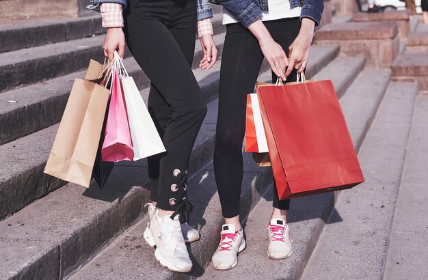 Dos joven llevando bolsas de la compra mientras caminaba por la calle después de visitar las tiendas.