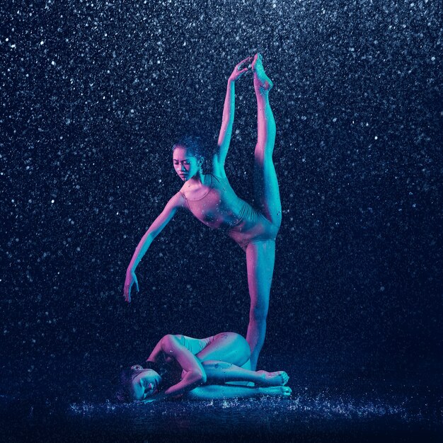 Dos jóvenes bailarinas de ballet bajo las gotas de agua