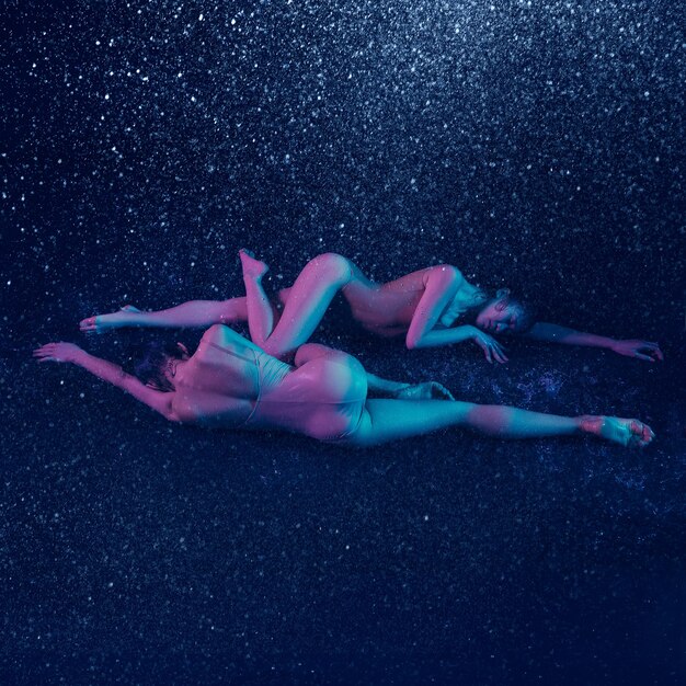 Dos jóvenes bailarinas de ballet bajo las gotas de agua