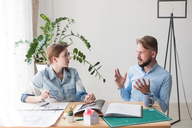 Dos jóvenes colegas discutiendo algo en la oficina