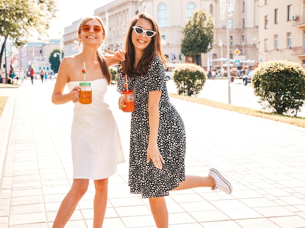 Dos jóvenes hermosas chicas hipster sonrientes en ropa de moda de verano